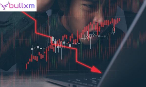 Businessman looking at a laptop screen with a red downward trend arrow, highlighting concerns about Bullxm's scam activities.